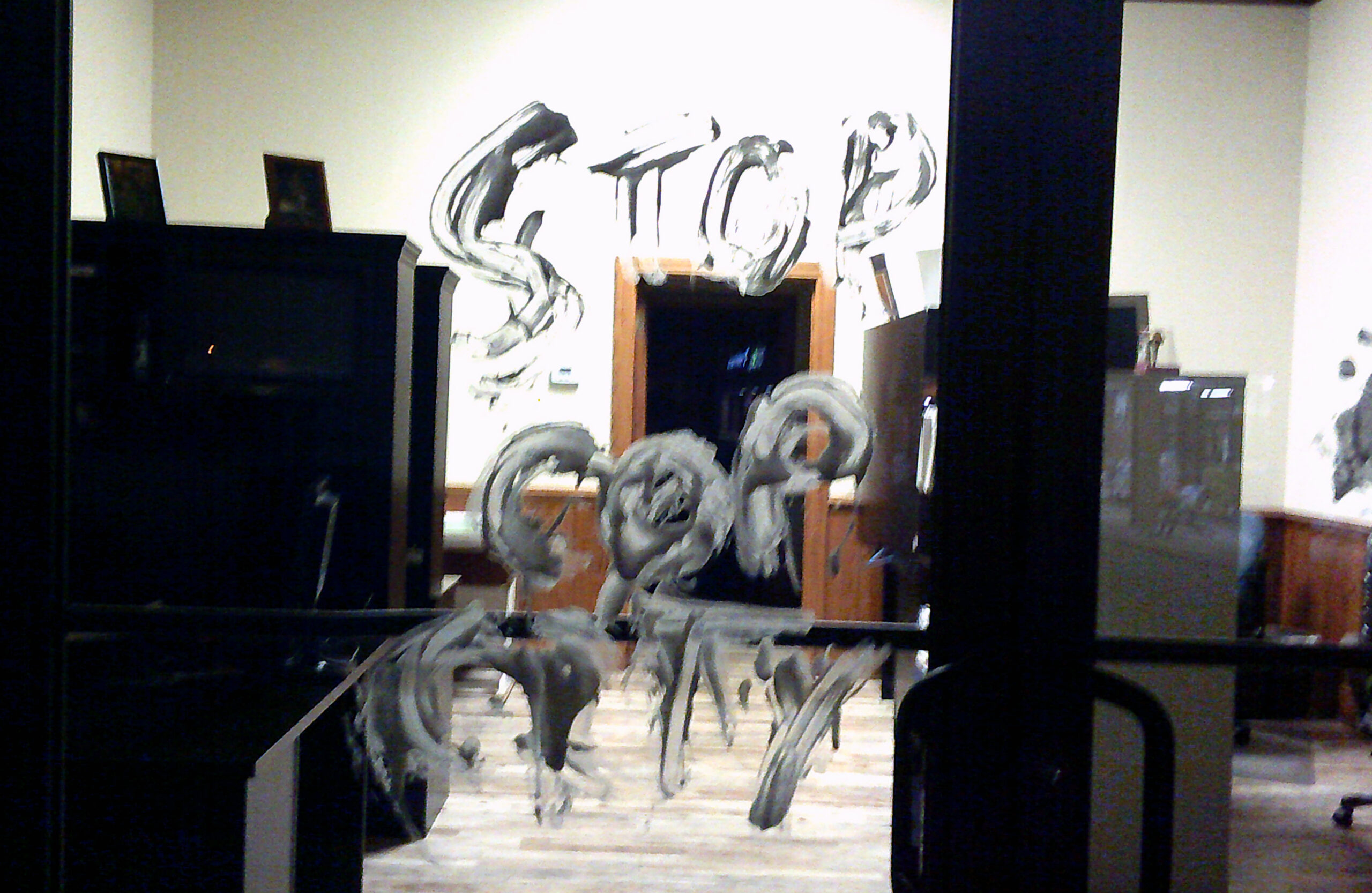 "STOP COP CITY" is painted in white over a window.