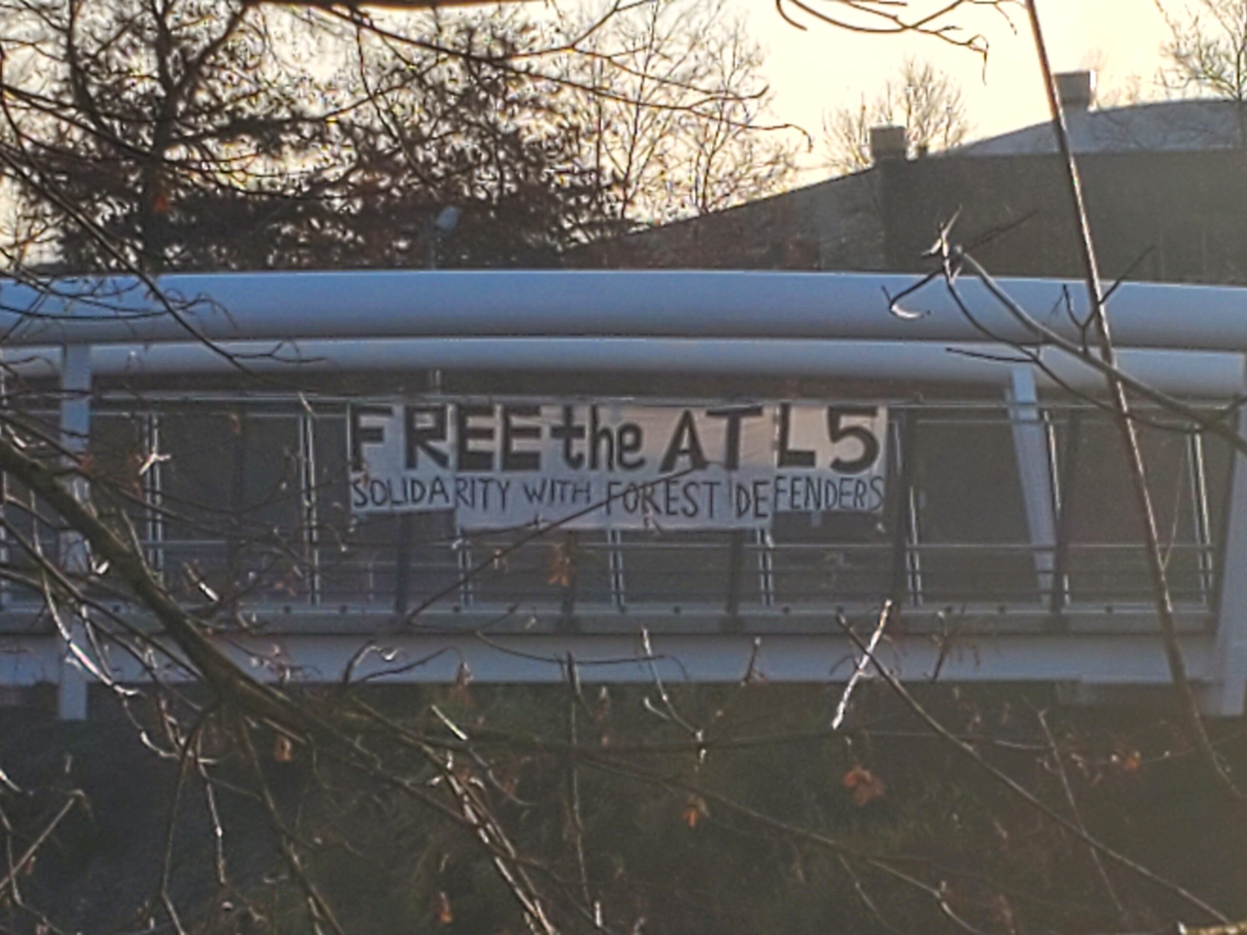 A close-up of a banner reading "FREE THE ATL 5 SOLIDARITY WITH FOREST DEFENDERS".