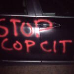 car with "STOP COP CITY" spray painted on side