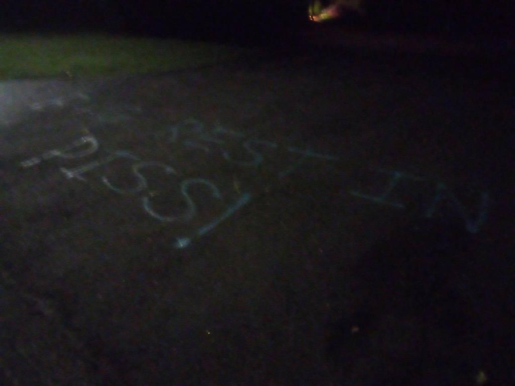 the words "B+G REST IN PISS" spray painted across the driveway.